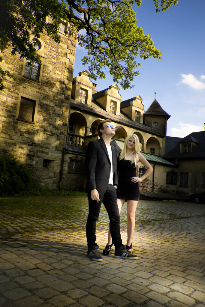 Paar beim Fotografen vor altem Schloss. 
